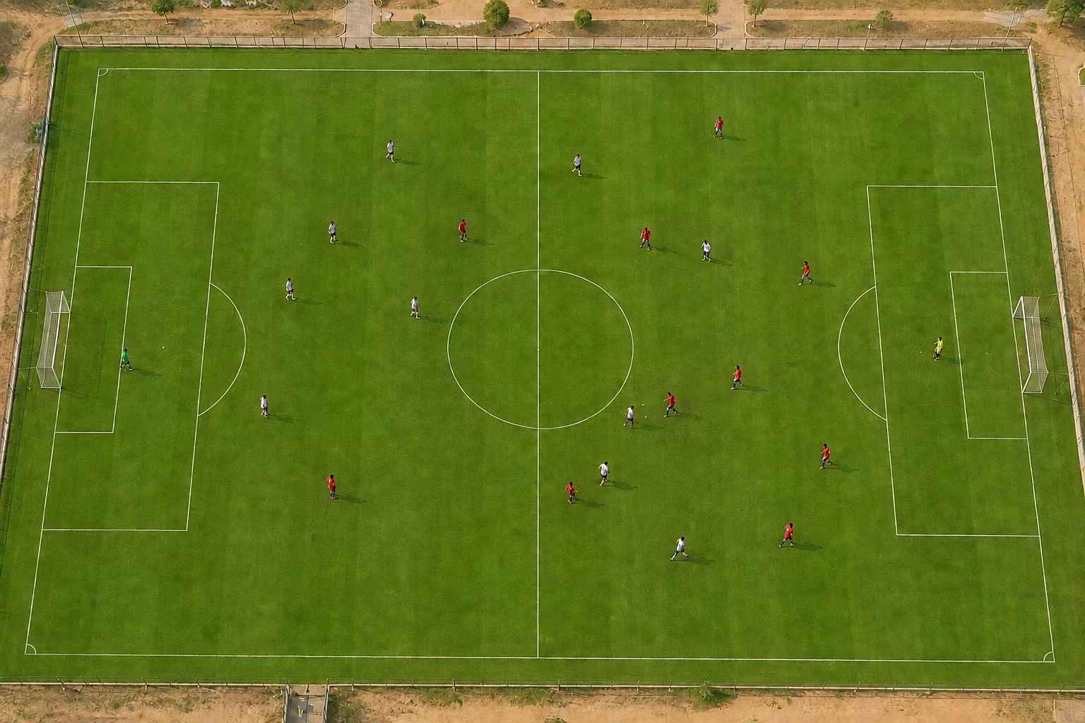 Overhead photograph of a youth football match, with players spread across the whole pitch
